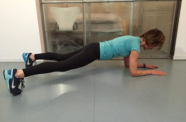 Plank met side step positie 2: zet 1 been opzij en weer terug